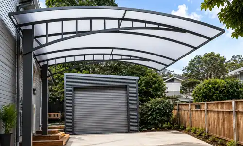 Curved roof car parking shade beside a residential building, suitable for covered parking structures in Saudi Arabia.