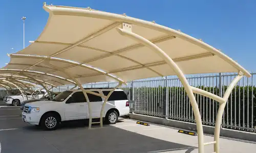 Outdoor fabric car parking shade with a curved support frame.