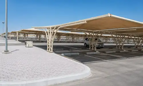 Multi-bay parking shade providing wide roof coverage for several cars.