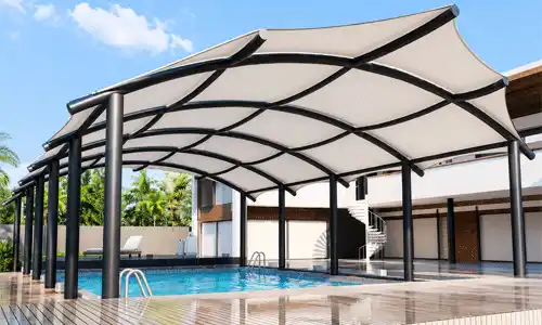 Modern parking shade with tensile roof near swimming pool.