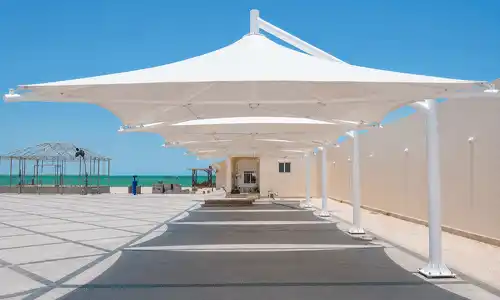 Luxury tensile shade installed beside swimming pool area.