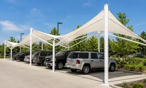 Tension fabric parking shade installed in a public parking space.