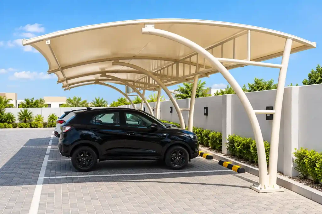 Curved tensile car parking shade structure with supporting poles.